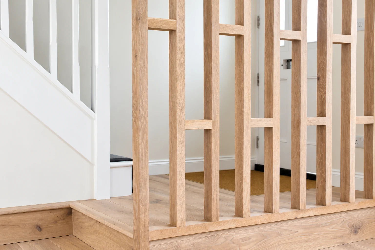 Timber stair screen with alternating crosspieces, vertical members and a raised base.