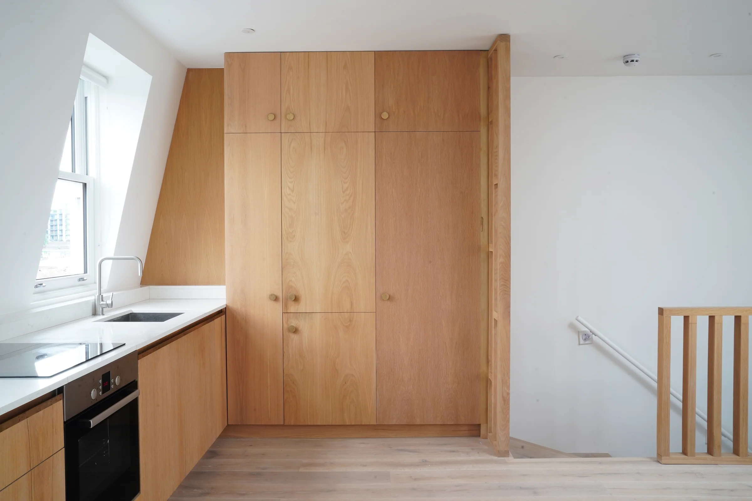 Full-height timber cupboards beside the penthouse stair opening.