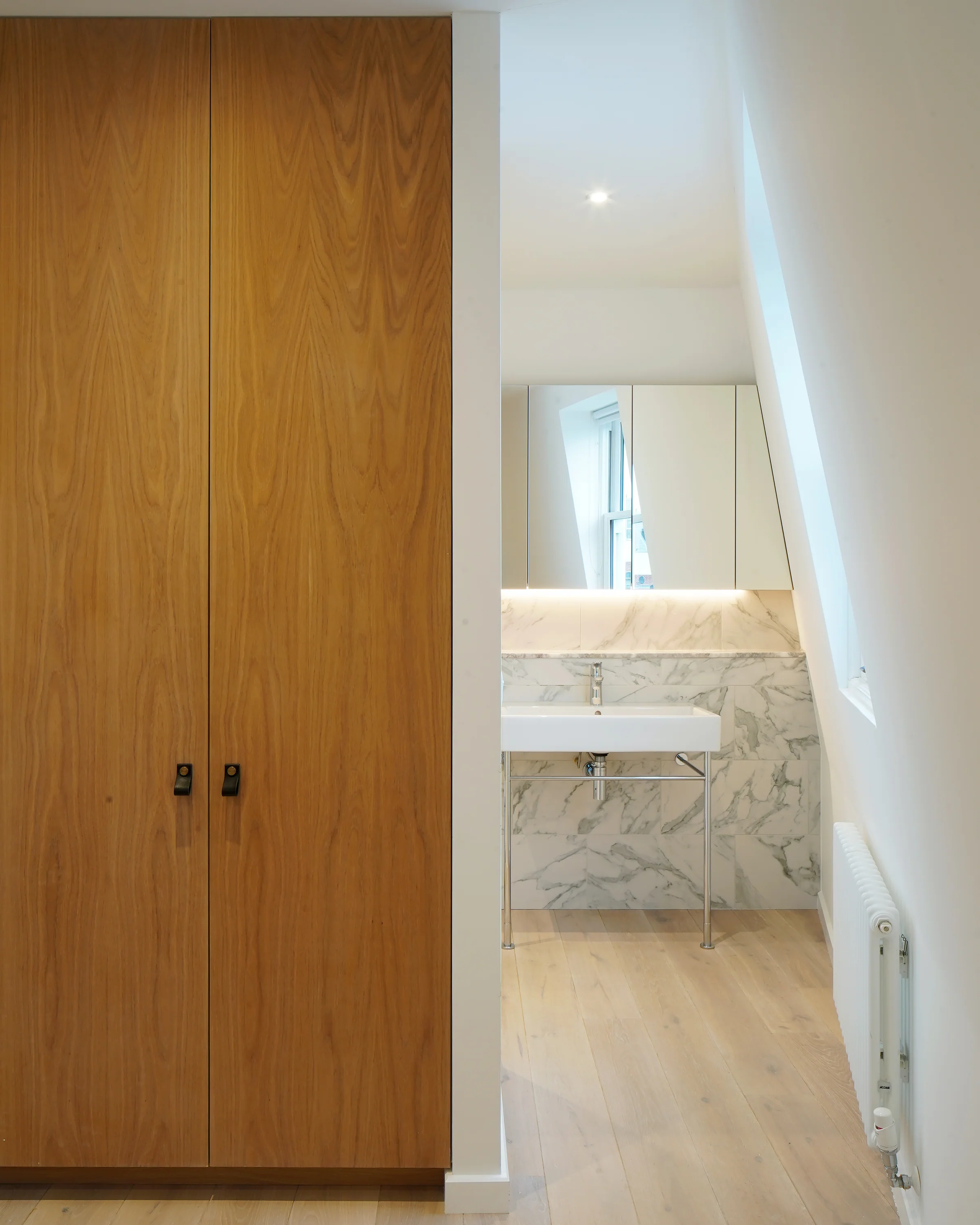 Timber cupboard door opening towards the penthouse bathroom.