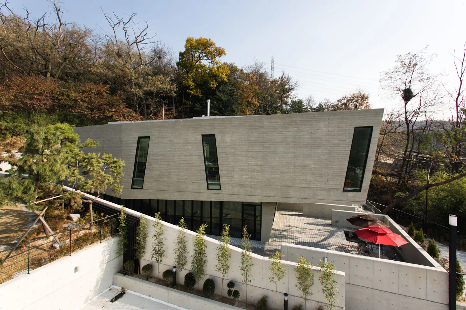 Daytime view of the concrete Gate House restaurant and lower terrace.